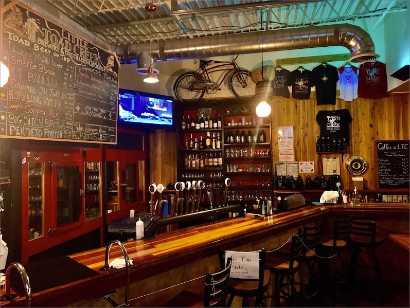 The inside of a brewery with a bike on the wall.