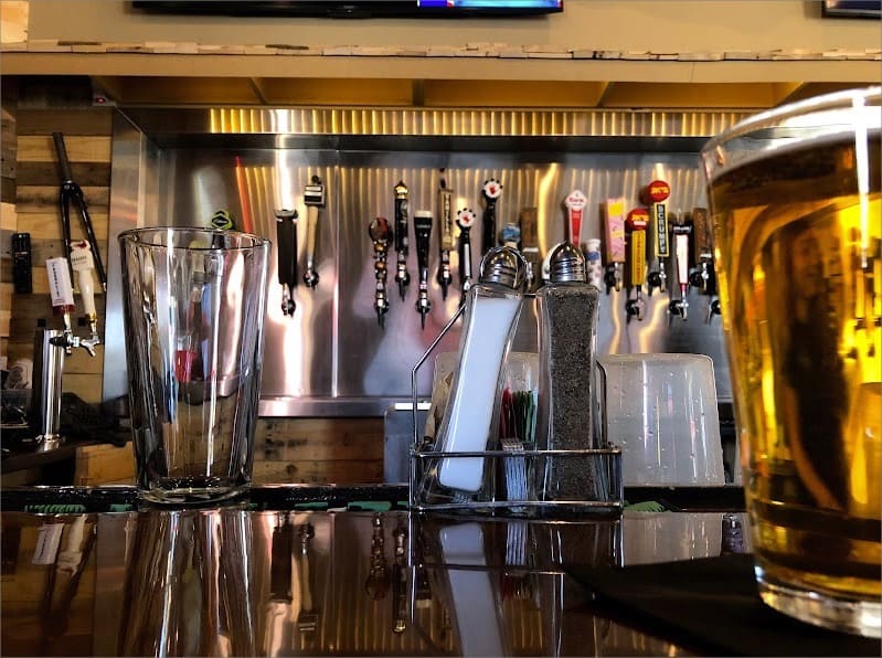 A glass of beer sits on a bar in a brewery.