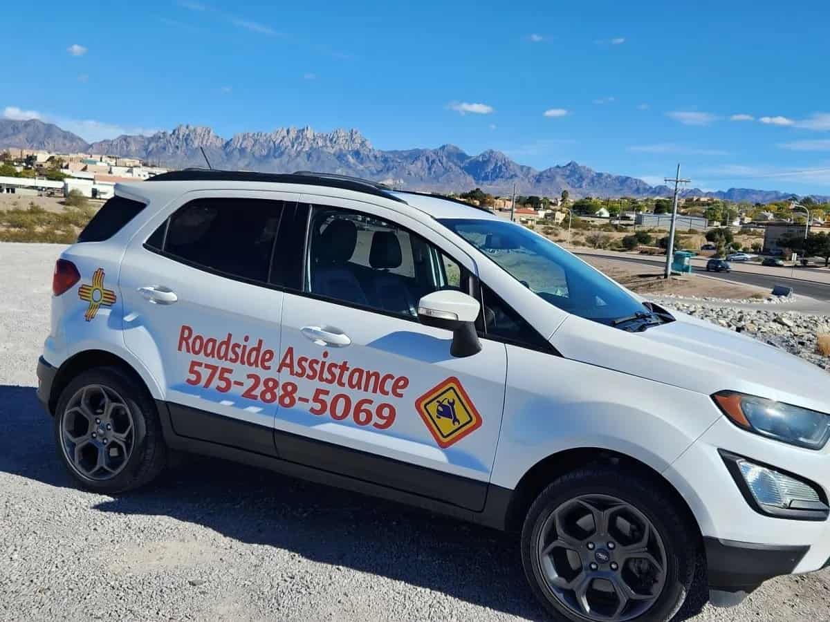 A white suv parked in a parking lot with mountains in the background. Keywords: Roadside Assistance